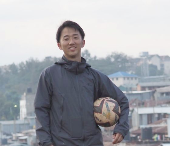 Takeyuki Tadokoro standing with a ball on a hillside above Nairobi